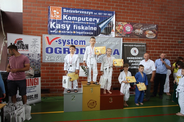 Zdjęcie uczniów na podium podczas odbioru nagród.