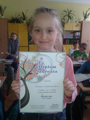 Zdjęcie uczennicy prezentującej otrzymany dyplom.