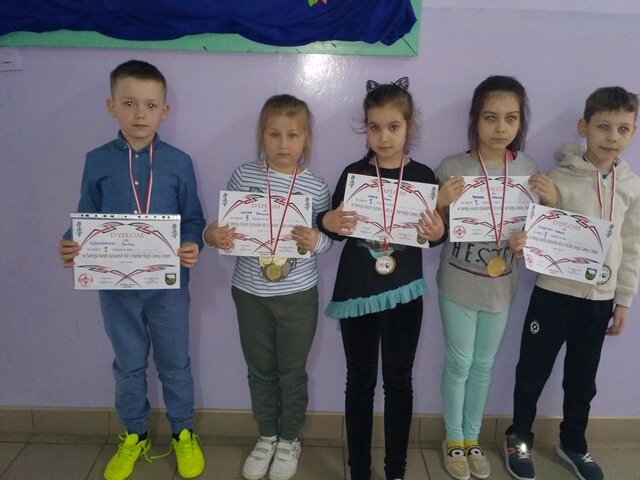 Trzy dziewczynki i dwóch chłopców  z dyplomami i medalami.
