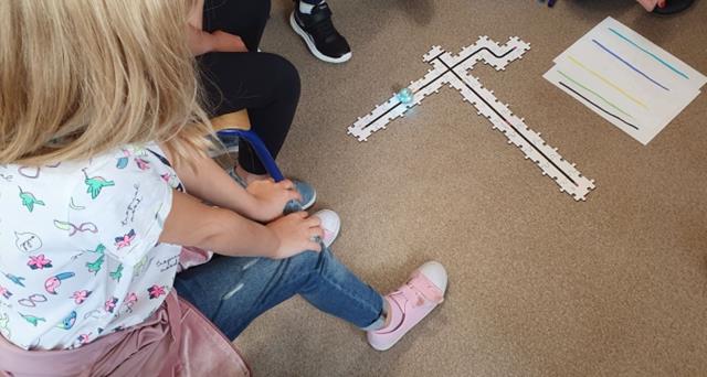 Zdjęcie dzieci z robotem Ozobot Evo.
