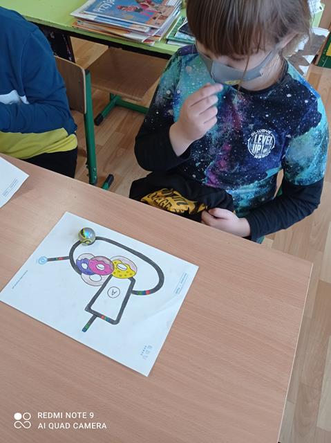 Uczniowie programujący drogę dla robota Ozobota.