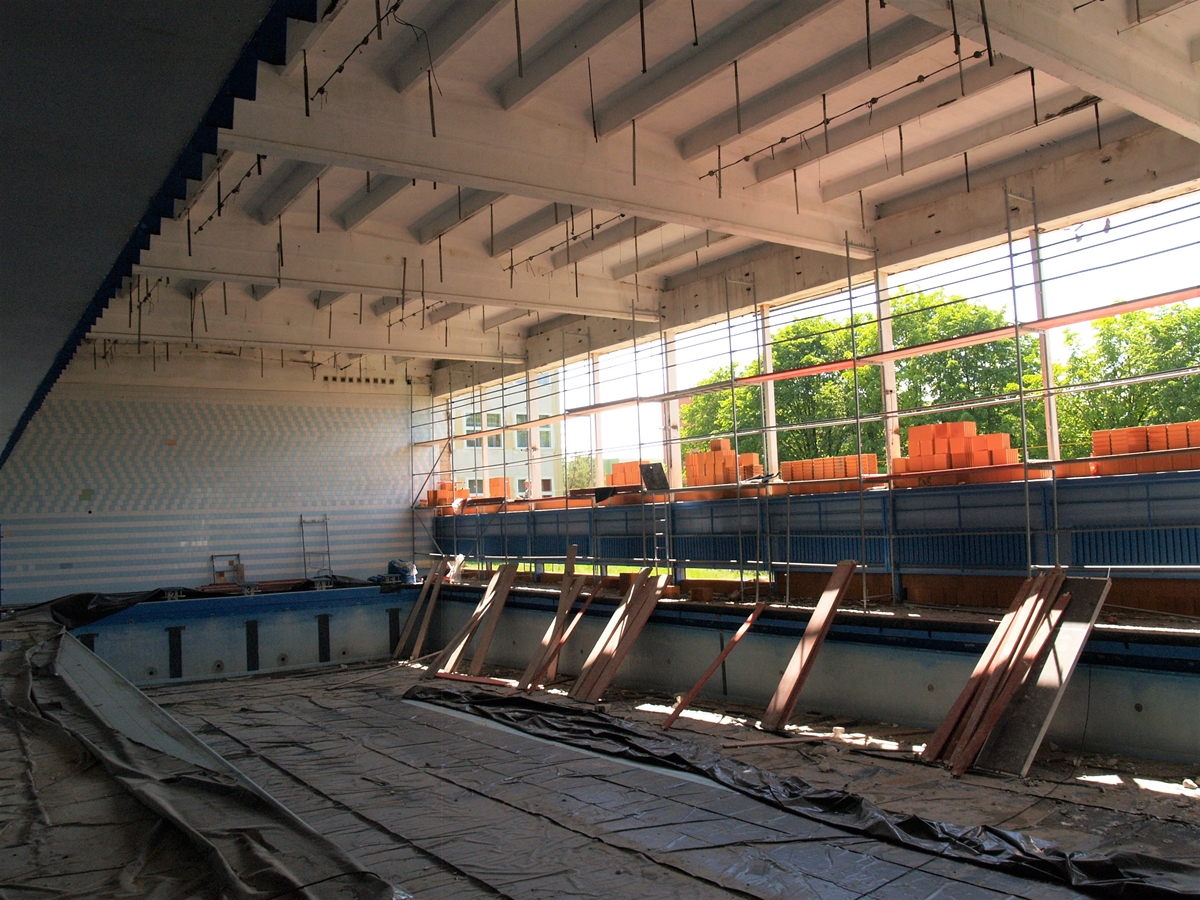Zdjęcie przedstawiające wnętrze hali basenu podczas budowy.