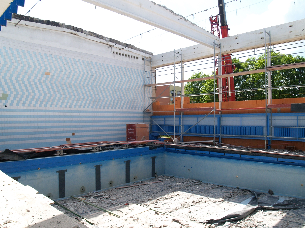 Zdjęcie przedstawiające wnętrze hali basenu podczas budowy. 