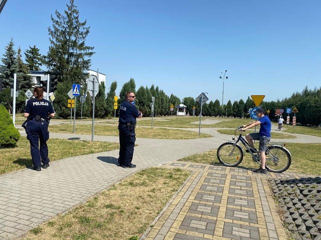 Zdjęcie przedstawiające policjantów i ucznia na rowerze podczas egzaminu na kartę rowerową.