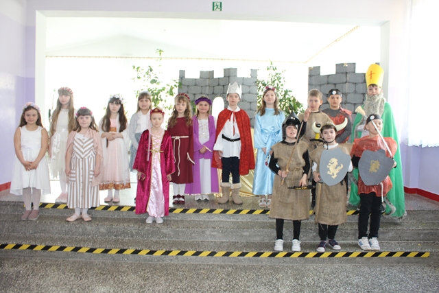 Zdjęcie przedstawia uczniów klas młodszych podczas przedstawienia z okazji rocznicy Chrztu Polski. 