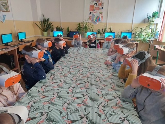 Grupa uczniów w pracowni informatycznej w czasie lekcji z okularami VR.
